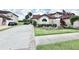 Charming home featuring a manicured lawn, mature landscaping, and a welcoming driveway, creating curb appeal at 26612 Bella Vista Dr, Howey In The Hills, FL 34737