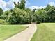 Paved golf cart path winding through lush greenery, trees, and manicured lawns at 26612 Bella Vista Dr, Howey In The Hills, FL 34737