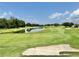 Scenic view of the golf course with a pond and lush green fairways at 26612 Bella Vista Dr, Howey In The Hills, FL 34737
