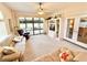 Bright living room with comfortable seating, ceiling fan, and sliding glass doors leading to the outdoors at 26612 Bella Vista Dr, Howey In The Hills, FL 34737