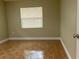 Bedroom boasts tile floors, a window with blinds, and neutral walls, offering a serene ambiance at 2701 S Dellwood Dr, Eustis, FL 32726