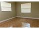 Bright bedroom featuring neutral walls, two windows with blinds, and warm-toned tile flooring at 2701 S Dellwood Dr, Eustis, FL 32726