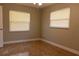 Inviting bedroom with two windows, neutral walls, and warm-toned tile flooring; simple yet elegant at 2701 S Dellwood Dr, Eustis, FL 32726