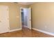Open bedroom with neutral walls and warm-toned tile flooring, with a doorway offering a glimpse into another room at 2701 S Dellwood Dr, Eustis, FL 32726