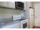 This kitchen features granite countertops, an oven, a microwave, and a refrigerator at 2701 S Dellwood Dr, Eustis, FL 32726