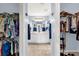 Bright bathroom featuring double sinks, white cabinetry, blue accents, and walk-in closets on either side at 2712 Plainridge Loop, The Villages, FL 32162
