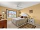 Bedroom with neutral carpet, a ceiling fan, large window and traditional furnishings at 2712 Plainridge Loop, The Villages, FL 32162