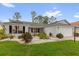 Inviting single-story home with a well-maintained lawn, a two-car garage, and colorful plants at 2712 Plainridge Loop, The Villages, FL 32162