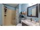 Bathroom featuring a sink, a mirror, a toilet, and a shower with blue walls at 2718 Lorraine Dr, Leesburg, FL 34748