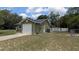 View of the side of the home, showing garage, yard, and a newly installed fence at 2718 Lorraine Dr, Leesburg, FL 34748