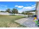A spacious backyard with a lush lawn, shade trees, and a covered patio area at 2889 Columbus Ave, Clermont, FL 34715