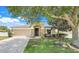 Charming single-story home with a well-manicured lawn, mature tree and inviting front entrance at 2889 Columbus Ave, Clermont, FL 34715