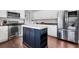 Kitchen boasts stainless steel appliances, white cabinets, hardwood floors and a central island at 2889 Columbus Ave, Clermont, FL 34715