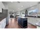 Open-concept kitchen features white cabinets, a dark island, stainless steel appliances, and hardwood floors at 2889 Columbus Ave, Clermont, FL 34715