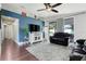 Cozy living room with a blue accent wall, hardwood floors and ample space for a comfortable seating arrangement at 2889 Columbus Ave, Clermont, FL 34715