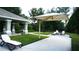 Pool house with lounge chairs and sun shade, surrounded by green landscaping at 2889 Columbus Ave, Clermont, FL 34715