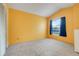 Bedroom featuring plush carpeting and a window with blue curtains, offering natural light at 2896 Picadilly Cir, Kissimmee, FL 34747