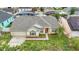 Aerial view of a cream home featuring a well-manicured lawn and neutral landscape beds at 2896 Picadilly Cir, Kissimmee, FL 34747