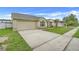 Home's exterior featuring a well-maintained lawn, driveway, and attached two-car garage at 2896 Picadilly Cir, Kissimmee, FL 34747