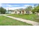 Charming single-story home with a well-manicured lawn and vibrant landscaping at 2896 Picadilly Cir, Kissimmee, FL 34747