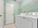A laundry room with a modern washer and dryer set next to a doorway at 2896 Picadilly Cir, Kissimmee, FL 34747