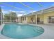 Backyard pool under a screened-in patio featuring lounge chairs and a ceiling fan at 2896 Picadilly Cir, Kissimmee, FL 34747