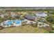 Aerial view of community amenities featuring a pool, clubhouse, and recreational areas surrounded by lush landscaping at 2928 Marlberry Ln, Clermont, FL 34714