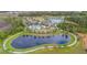 Aerial view of the community featuring a pool, clubhouse, and scenic walking trail surrounding a pond at 2928 Marlberry Ln, Clermont, FL 34714