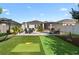 The backyard features a patio with lounge chairs, outdoor grill, putting green, and privacy landscaping at 2928 Marlberry Ln, Clermont, FL 34714