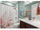 Bright bathroom featuring a shower with floral curtains and a white vanity at 2928 Marlberry Ln, Clermont, FL 34714