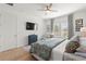 Bright bedroom featuring wood floors, stylish decor, a mounted TV, and plush bedding for comfortable living at 2928 Marlberry Ln, Clermont, FL 34714