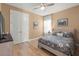 Comfortable bedroom with a floral-patterned bedspread, wood floors, and ample natural light at 2928 Marlberry Ln, Clermont, FL 34714