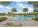 Large community pool with palm trees, lounge chairs, and lush landscaping in a tropical setting at 2928 Marlberry Ln, Clermont, FL 34714