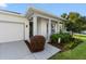 Inviting front porch with elegant columns, vibrant landscaping, and a charming welcome wreath at 2928 Marlberry Ln, Clermont, FL 34714