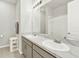 Bright bathroom featuring a double sink with marble countertop and a large framed mirror at 31760 Broadwater Ave, Leesburg, FL 34748