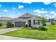 Charming single-story home featuring a well-manicured lawn, landscaped garden beds, and an attached two-car garage at 31760 Broadwater Ave, Leesburg, FL 34748