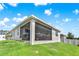 Back exterior view of the house featuring a screened-in patio and a lush green yard at 31760 Broadwater Ave, Leesburg, FL 34748
