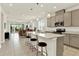 Open-concept kitchen features stone countertops, a breakfast bar with seating, and stainless steel appliances at 31760 Broadwater Ave, Leesburg, FL 34748