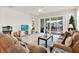 Cozy living room with a comfortable sofa, entertainment center, and sliding glass doors to outdoor living at 31760 Broadwater Ave, Leesburg, FL 34748