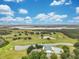 Beautiful aerial view of the community golf course, pool and clubhouse with a pond and blue skies at 33417 Pennbrooke Pkwy, Leesburg, FL 34748
