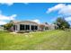 Spacious backyard featuring a screened-in lanai and lush green lawn, ideal for relaxation at 33417 Pennbrooke Pkwy, Leesburg, FL 34748