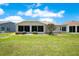 Backyard view featuring the lanai and green lawn at 33417 Pennbrooke Pkwy, Leesburg, FL 34748