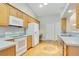 Well-lit kitchen with light wood cabinets, white appliances, and hardwood floors at 33417 Pennbrooke Pkwy, Leesburg, FL 34748