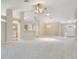 Spacious living room with carpet, ceiling fan, and arched entryway to kitchen with updated appliances at 33417 Pennbrooke Pkwy, Leesburg, FL 34748