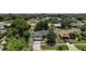 An aerial view of a single-story home with a lush green lawn and a backdrop of mature trees and neighborhood homes at 3677 Park Green Ct, Tavares, FL 32778