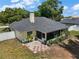 Aerial view of the home with a back patio, chimney and a fenced-in yard with mature trees at 3677 Park Green Ct, Tavares, FL 32778