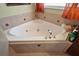 Relaxing bathtub area with decorative tiles and natural light from the window at 3677 Park Green Ct, Tavares, FL 32778