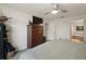 Bright bedroom with carpeted floors, ceiling fan, and dresser near the bathroom at 3677 Park Green Ct, Tavares, FL 32778