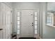 Bright entryway featuring a white front door with sidelights, complemented by neutral walls and flooring at 3677 Park Green Ct, Tavares, FL 32778