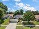 Charming single-story home with an attached two-car garage, lush landscaping, and a well-manicured lawn at 3677 Park Green Ct, Tavares, FL 32778